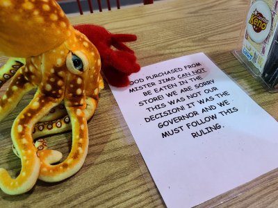 Woomy looks at the note on the table advising patrons that they are not allowed to consume food in the store due to coronavirus-related decrees handed down by the Virginia governor.