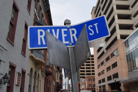 Bent street signs at the intersection of River and Walnut Streets.