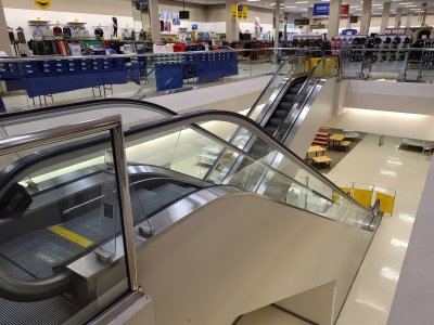 Escalators going down to the lower level, shut off and barricaded.  Only the far end of the lower level (furthest from the camera) was accessible to customers via a stairway and an elevator for access to the portrait studio and the restrooms.