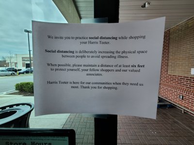 Sign on the door at the Harris Teeter in Ellicott City asking people to practice social distancing.