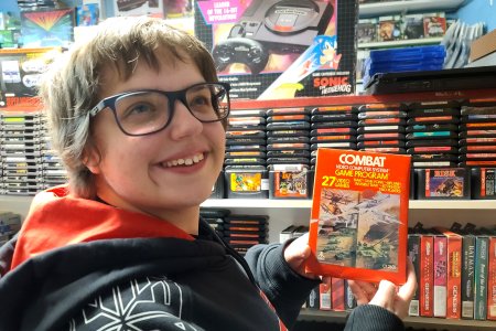 Elyse holds up a copy of Combat, which is a favorite Atari 2600 game of hers.  I taught her how to play it a while back, and she's pretty good at it, though she tends to get mad at me when I shoot her vehicle too many times.