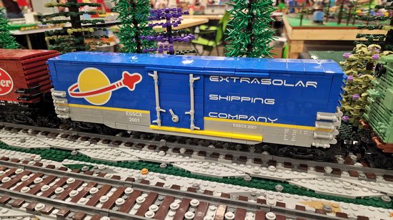 Lego freight railcar done up with the Lego space logo, called the Extrasolar Shipping Company, with reporting mark ESSCX.