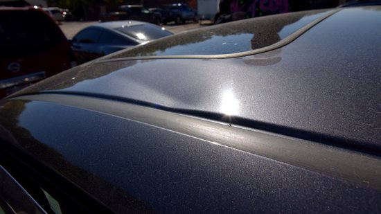 I found this bit of damage to be somewhat curious.  These are little dents on either side of the moon roof - one on each side.  I can understand how the one on the left side of the car (top photo) happened, since that's the side that took the impact, but the one on the right (bottom photo) surprised me, being on the off-side.