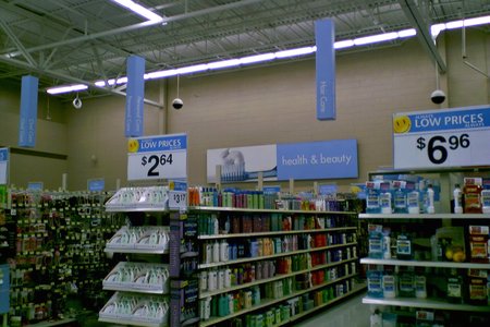 Health and beauty section, with the big wall sign in back, and the little pylon signs over the aisles.  I found the little pylon signs to be less than helpful, mainly because they were small, and the text was hard to read, with its being printed in white on a light surface, not being very bold, and being oriented vertically.  I ended up ignoring those signs completely and navigating without them.