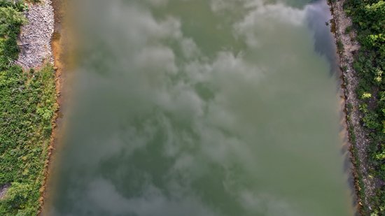 Overhead view of Mills Creek Reservoir, showing the reflection of the clouds on the surface of the water.