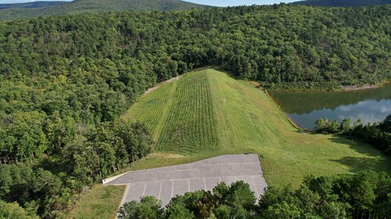 The dam for this reservoir is an embankment dam, with grass growing on both sides.