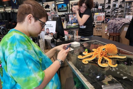 Elyse photos Woomy while an employee looks on.