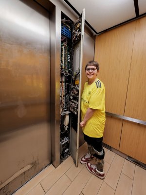 Elyse stands with the elevator panel, clearly not properly affixed.
