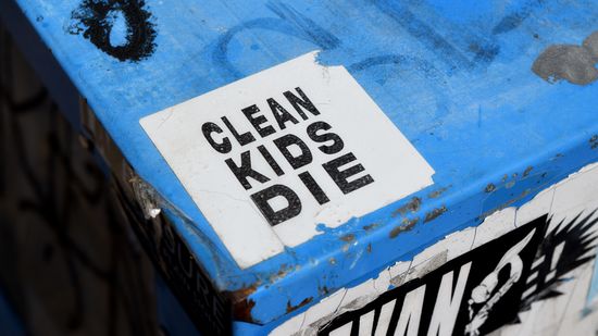 "CLEAN KIDS DIE" sticker on a newspaper box.