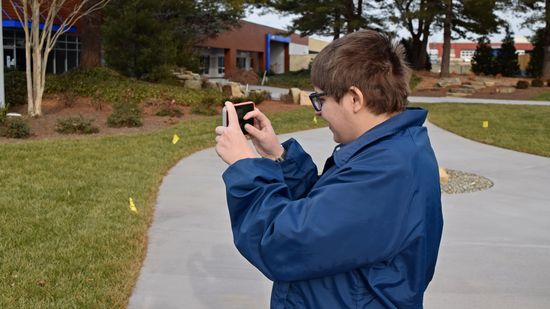 Elyse photographs the Scrub Daddy building with her phone.