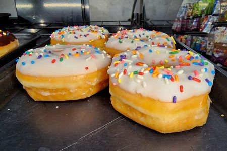 Vanilla iced donuts with sprinkles.