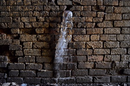 A stream of ice originating from the brick lining of the tunnel.  There was a lot of ice in the tunnel, both on the walls and hanging from the ceiling, and there were remnants of former icicles and other bits of ice on the ground.  Despite that it was in the sixties outside on this particular day, it was still quite cold in the tunnel.