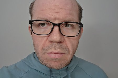 Black glasses, in a selfie at home.