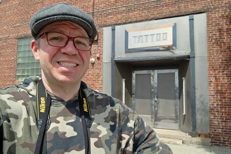 Red glasses, in front of the Ink Master shop.