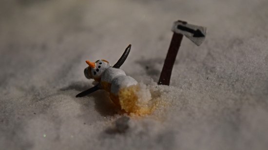 A snowman laying on its side in Petit Québec, as part of a ski resort display.
