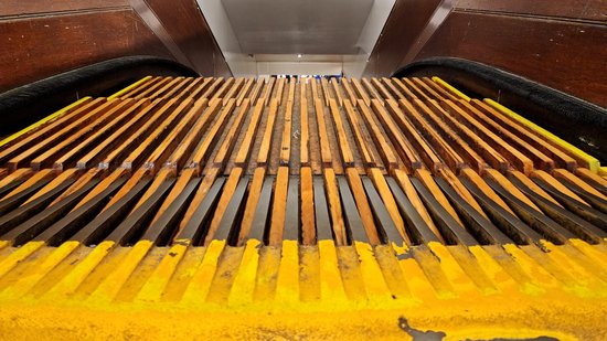 Wooden escalators at Macy's Herald Square. Similar to the width of the grooves, note the width of the teeth on the comb plate at the end of the escalator.