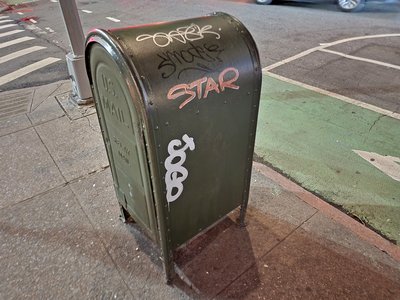 Mailbox with some graffiti at the corner of Varick Street and Downing Street.