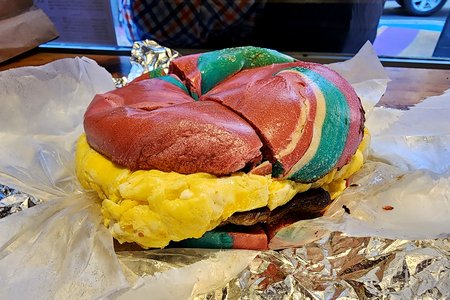 My breakfast, consisting of sausage and egg on a rainbow bagel.