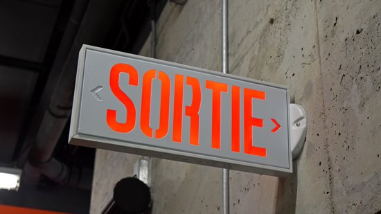 Exit sign at the Gatineau Sports Center, which we wandered into while looking for the transit hub.  Note that it says "SORTIE", i.e. it is only in French, rather than being bilingual or using the running man.