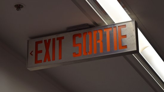 Bilingual exit sign.  About the only place that I saw these signs was at the airport.  Everywhere else used either the running man or was English-only.