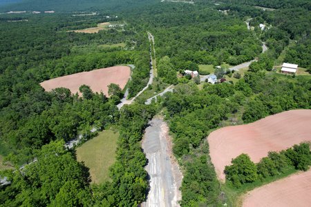 Abandoned Pennsylvania Turnpike, running top to bottom in this photograph.  The PTC-owned section is in the bottom half of the photo, below US 30, and the conservancy-owned section is in the top half.  The conservancy-owned section is open to the public as a hiking/biking trail, while the PTC-owned section is not open to the public.