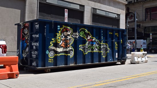 Construction dumpster on the street, painted with a Mario theme.