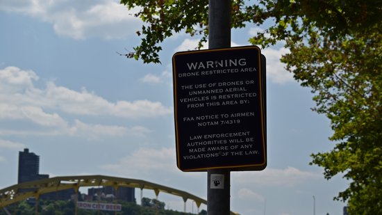 Sign threatening police action regarding use of drones in this area.  For those wondering, NOTAM 7/4319 concerns drone activities around stadiums on days when the stadium is in active use.  Though I could totally see some overzealous and underinformed security or law enforcement person trying to tell someone that they can't fly here at all, when that's absolutely not the case.  I blame the sign, because it fails to state that it only applies when the stadium is hosting an event.