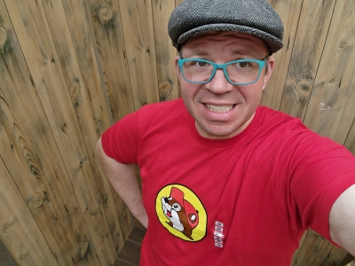 Trying on a red Buc-ee's shirt with the beaver mascot on it.