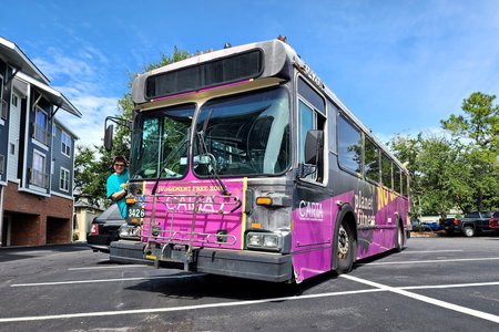 Elyse leans out of the door for a photo with the bus.