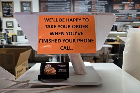 "We'll be happy to take your order when you've finished your phone call."
