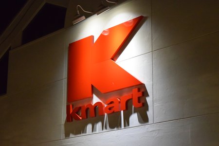 Externally-lit red Kmart logo on the front of the building.  This external lighting is part of the shopping center's standard design, as all tenants here had similar lighting setups.