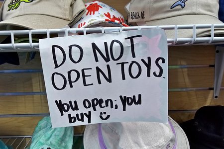 Sign at Tidal Rave's 5 & 10, admonishing customers not to open toys, and warning that if they do open something, they are obligated to buy it.  I always wonder if these sorts of policies are legally enforceable, but I'm guessing not.