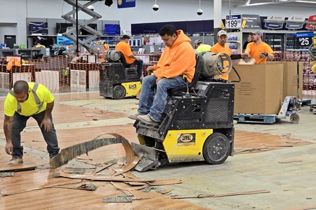Using machinery to remove the wood-look tile floors in the clothing department.