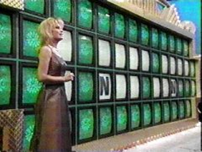 Vanna White standing in front of the puzzleboard on an episode of Wheel of Fortune