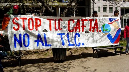 A group of people hold up a large banner advocating the defeat of the Central American Free Trade Agreement (CAFTA). More information at stopcafta.org.