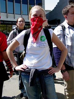 A masked woman wears a shirt saying "Fight for the right, not for the wrong/Going there, I'm growing there/Helping the weak against the strong."