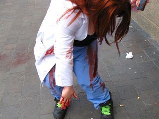 A soon-to-be zombie applies blood on her clothing.