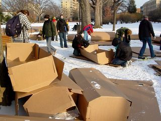 The cardboard coffins were being assembled by volunteers on the side of the rally site. Some of the coffins were covered with black cloth, and others were covered by American flags.