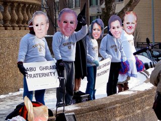 At a street corner, I encountered people wearing large cutout masks representing George W. Bush, Donald Rumsfeld, Condoleezza Rice, and other members of the Bush administration. Another person was also dressed as the hooded Abu Ghraib prisoner that was shown in a photograph first made public in May 2004.