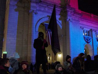 The person who seemed to be the icon of our demonstration was a small woman wearing the standard black mask, holding up a large black flag nearly as tall as she was.