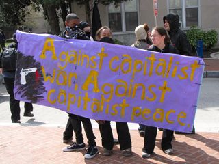 Holding one of the banners on a section of sidewalk to the west of Washington Circle.