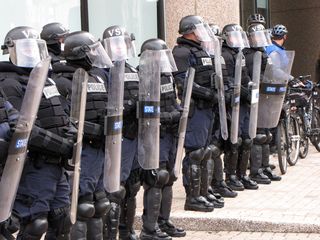 Meanwhile, the Virginia State Police (above) and local police (below), in full riot gear, formed a line preventing movement towards the buildings. And despite my best attempts to get some of them to smile, they maintained their poker faces.