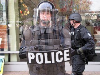 Meanwhile, the Virginia State Police (above) and local police (below), in full riot gear, formed a line preventing movement towards the buildings. And despite my best attempts to get some of them to smile, they maintained their poker faces.