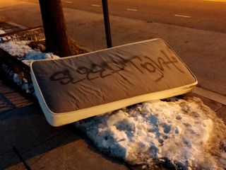 I spotted this on the side of 14th Street NW on February 28. "Sleep tight" is written on the mattress in spray paint. Kind of creepy, no?