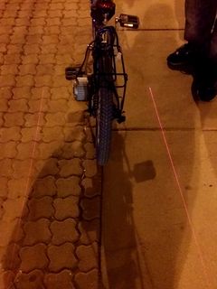 I spotted this on Georgia Avenue on the evening of April 16. This is a bike-mounted laser that projects two lines onto the sidewalk, delineating a keep-out zone on either side of the bicycle.