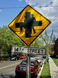 This sign, photographed May 2, on the 1400 block of Aspen Street NW in DC, consists of two different legends printed over each other: the intersection sign over top of the family version of pedestrian crossing. Regarding this juxtaposition, I commented at the time that this must mean that we can run people over at this intersection.