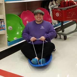 Pretending to go sledding in Target. We used to have one just like this when I was a child, but in orange.