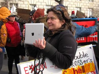 Sign of the times: a woman uses an Apple iPad to take photos of the march.