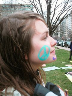 Face painting, with a peace sign on one side, and catlike features on the other.
