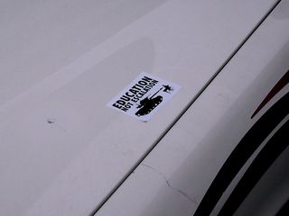 "Education Not Escalation" sticker placed on a police car.
